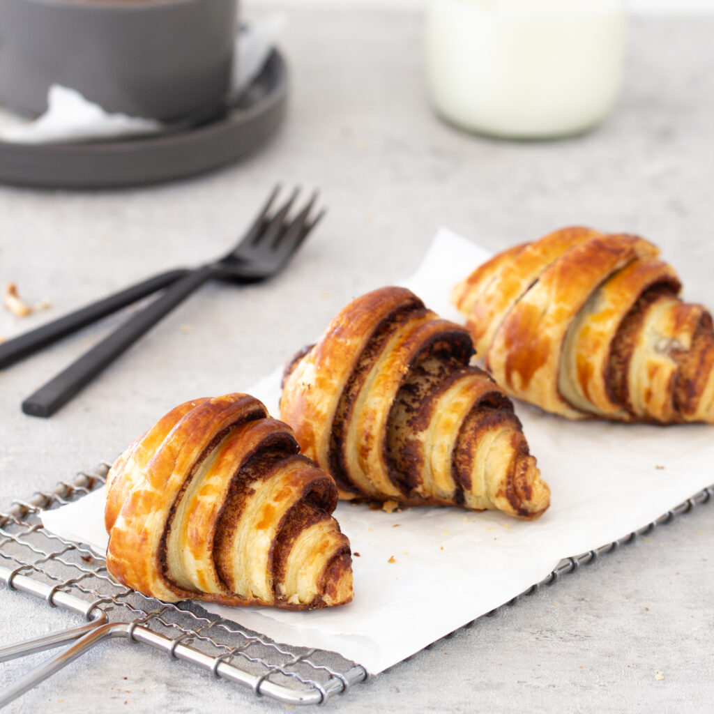 Drei Mini Schoko Croissants mit Nutella / Nuss-Nougat-Creme auf einem Gitter