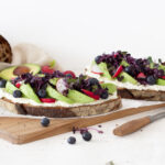 Bauernbrot üppig belegt mit Frischkäse, Avocado, Radieschen und Blaubeeren