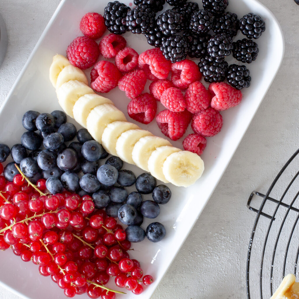 Zutaten für Beeren-Topping, nebenan liegen frisch gebackene belgische Waffeln