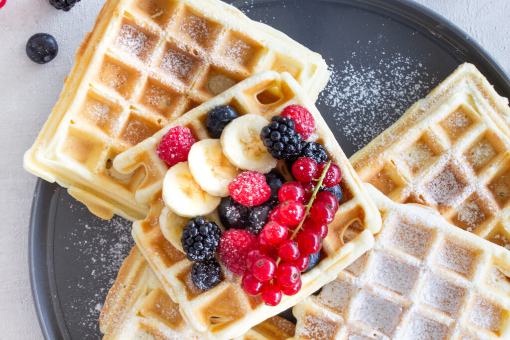 Belgische Waffeln mit Beeren-Topping und Puderzucker auf einem Teller