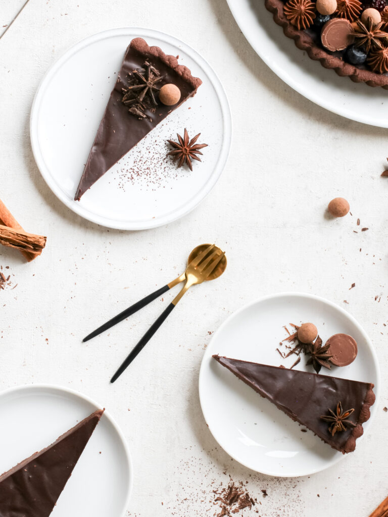 Mehrere Stücke Schokoladen-Lebkuchen-Tarte mit opulentem edlem Topping, von oben fotografiert