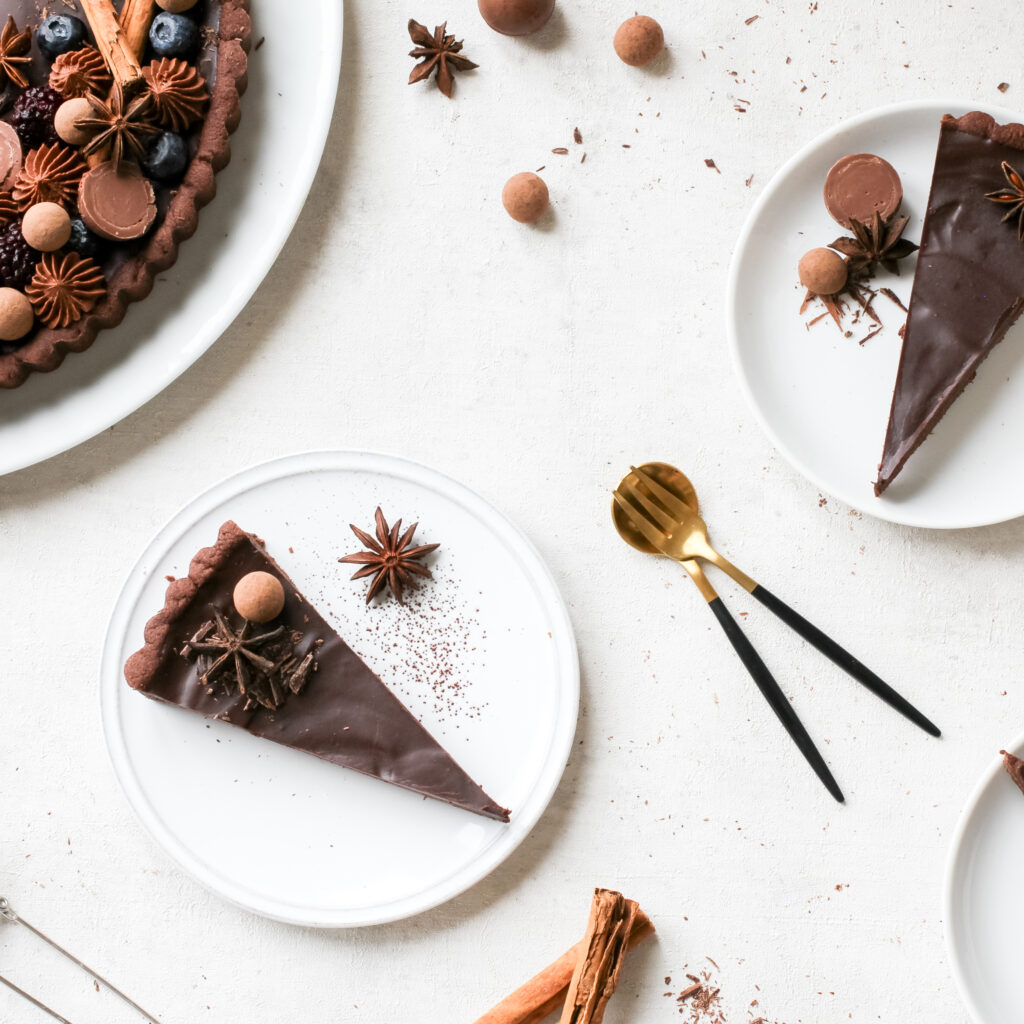 Mehrere Stücke Schokoladen-Lebkuchen-Tarte mit opulentem edlem Topping, von oben fotografiert