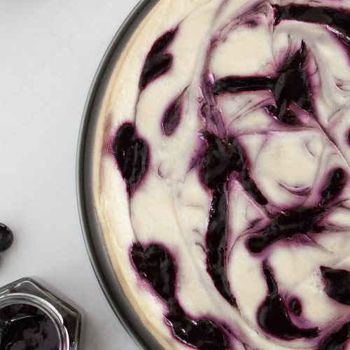 New York Cheesecake mit Blaubeerswirl New York Cheesecake mit einem Swirl aus Blaubeeren am Stück